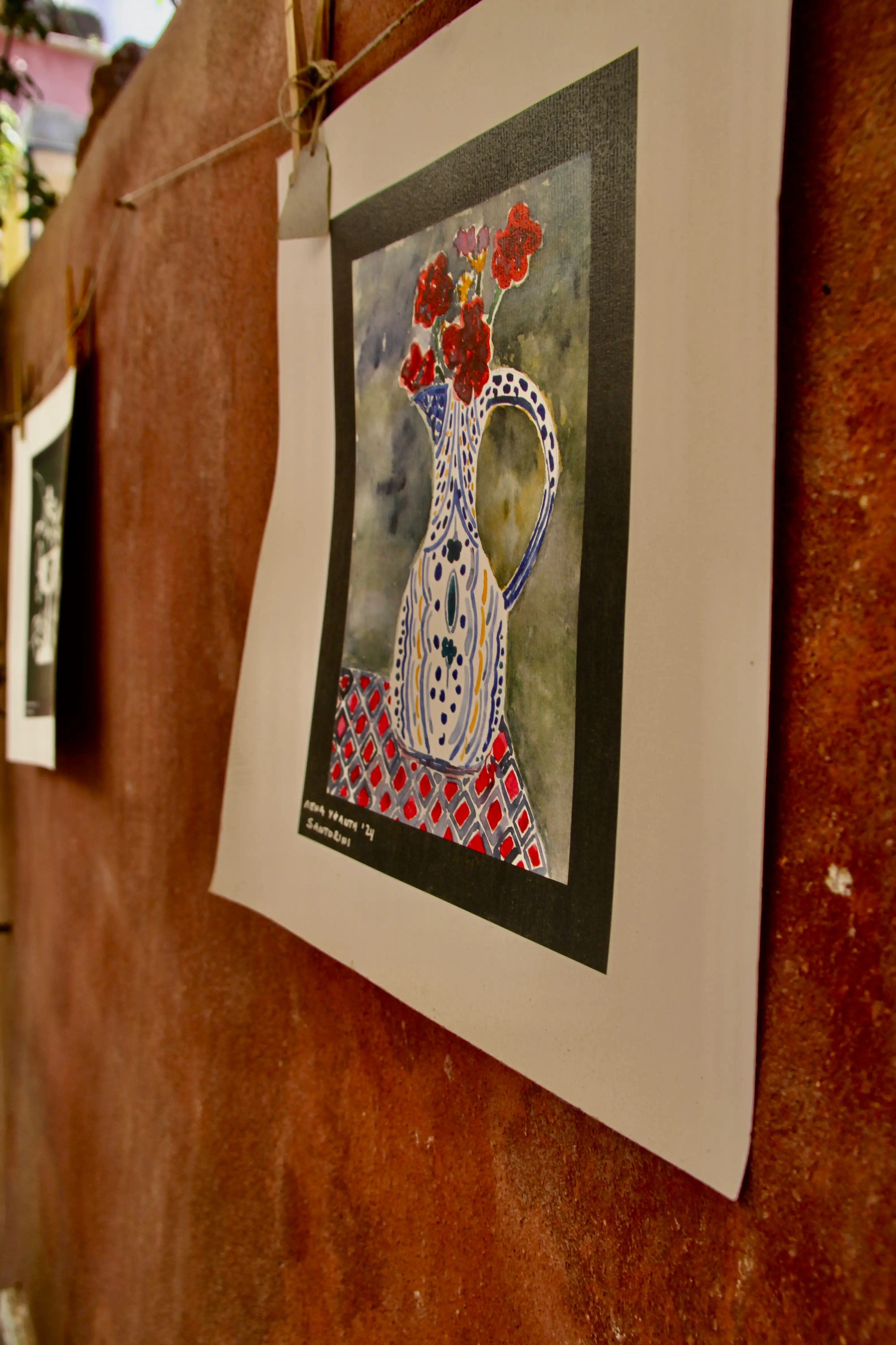 Framed patterned vessel artwork on an aged wall