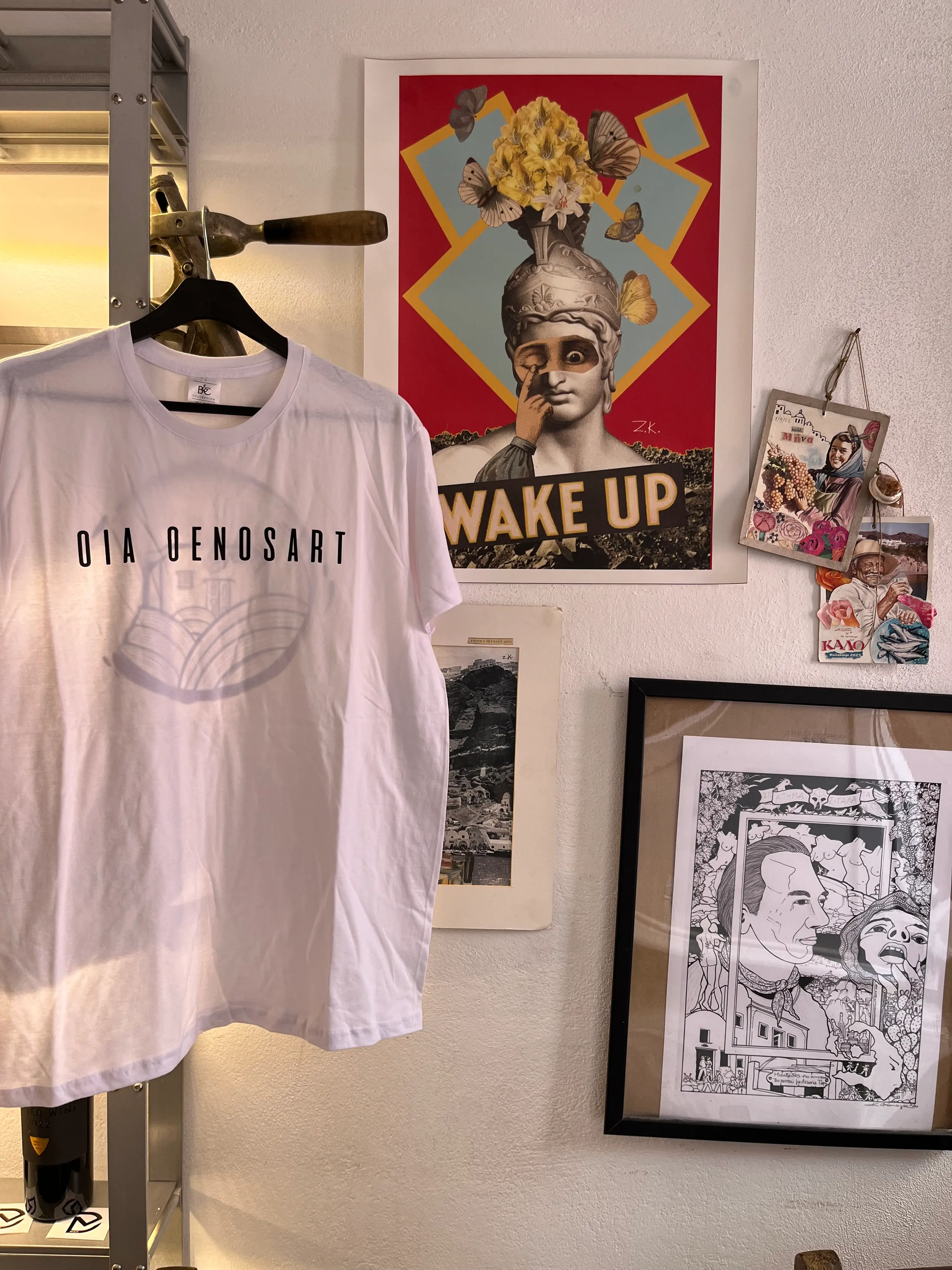 Oia Oenosart shirt displayed among framed graphic artworks