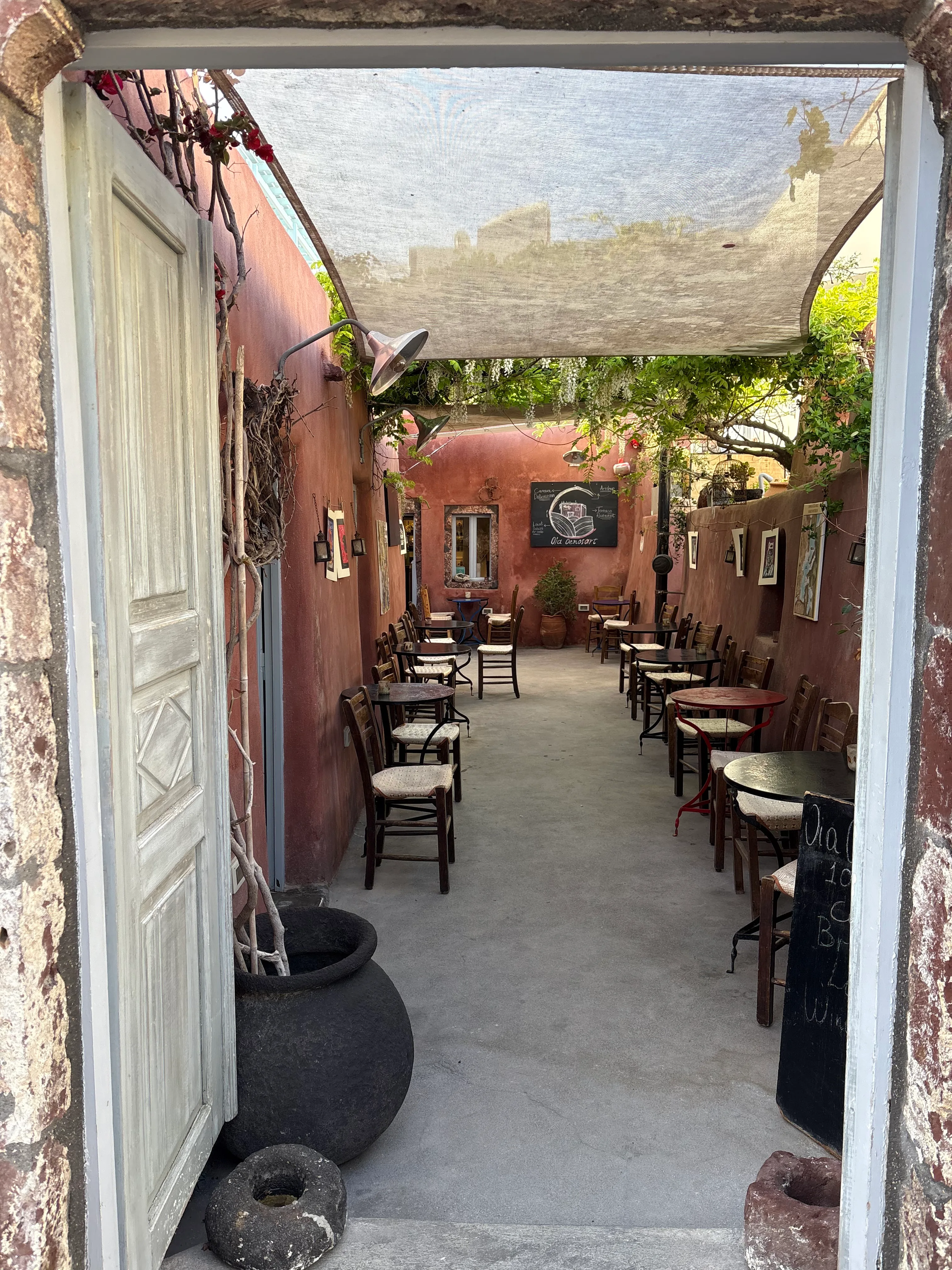 Tables and rush chairs in the Oia Oenosart garden